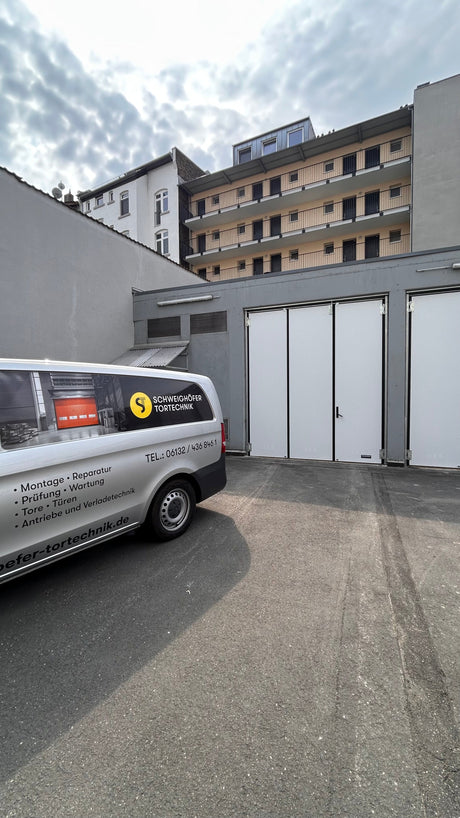 Tormeister24 Techniker prüft ein großes Industrietor in einer Logistikhalle