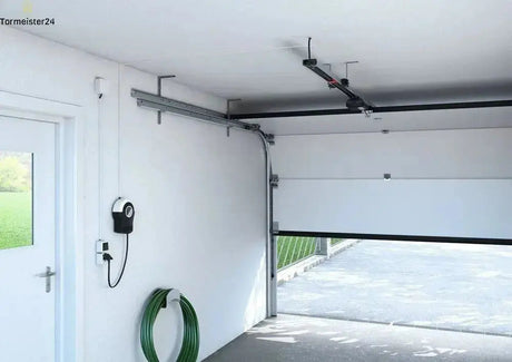 Garagentor mit montiertem Deckenantrieb, Schiene und Motor im Innenraum der Garage sichtbar