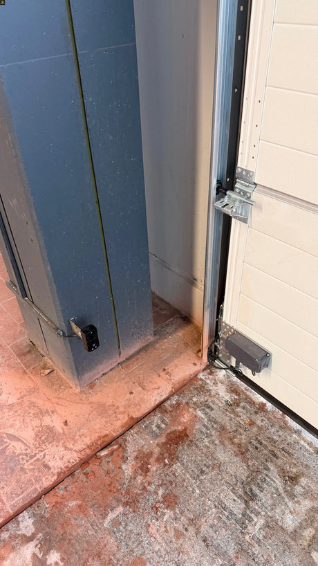 Techniker prüft Torsteuerung und Sicherheitskreis an einem Sektionaltor, das nur im Totmannbetrieb schließt